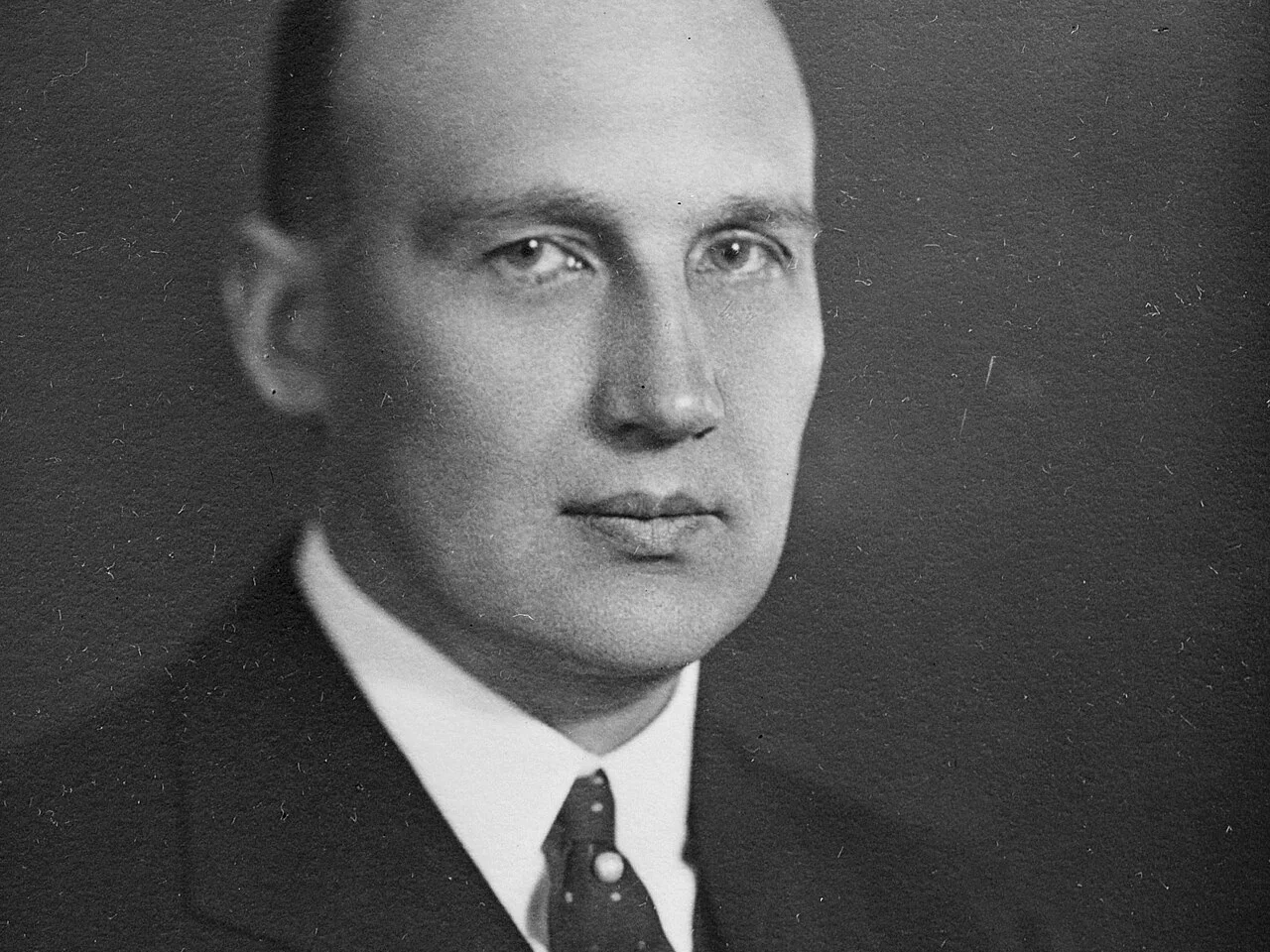 Svartvitt studioporträtt av finansmannen Ivar Kreuger i mörk kostym och prickig slips, cirka 1920